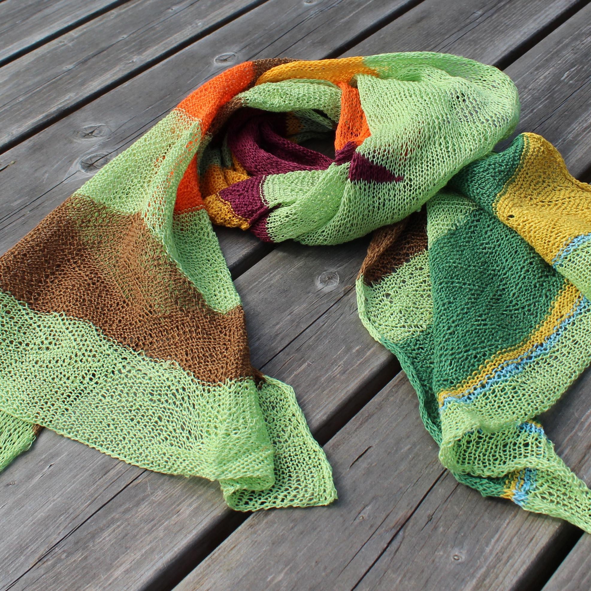 Colorful knitted scarf on a wooden surface