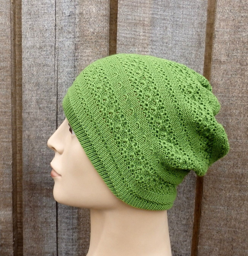 Green knitted beanie on a mannequin head against a wooden background