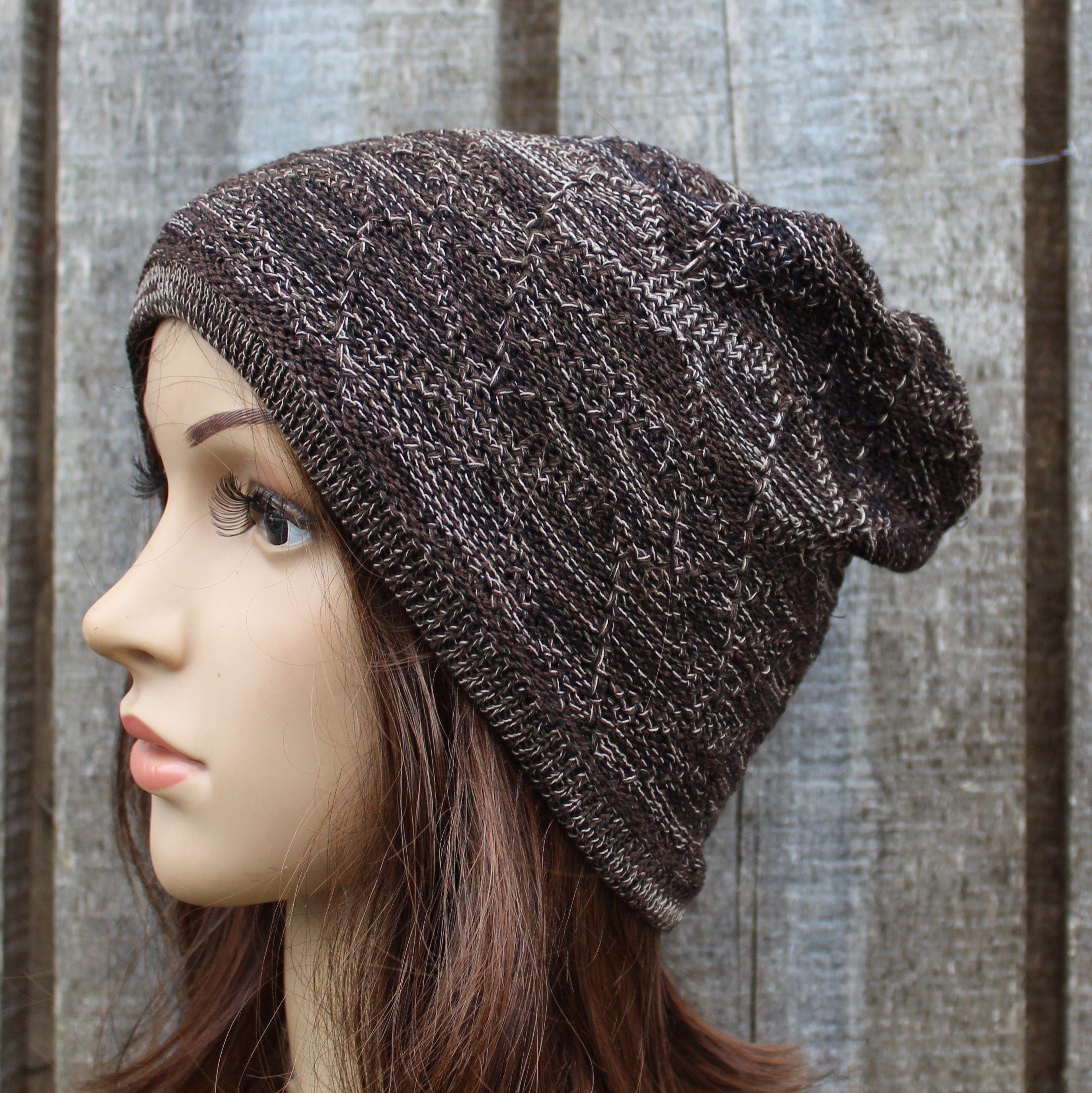 Brown knitted beanie on a mannequin head against a wooden background