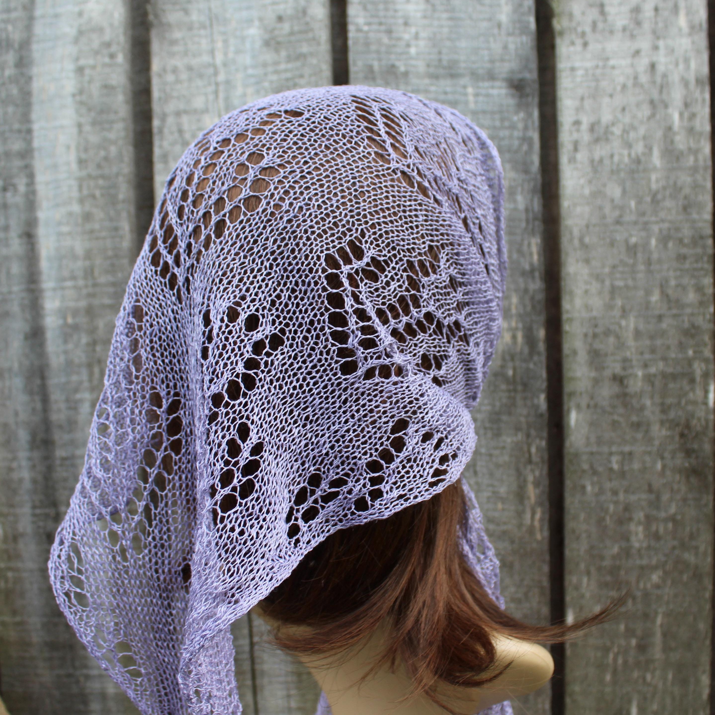 Lace shawl draped over a mannequin head against a wooden background