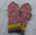 Pair of knitted mittens with a pink and brown pattern on a gray background
