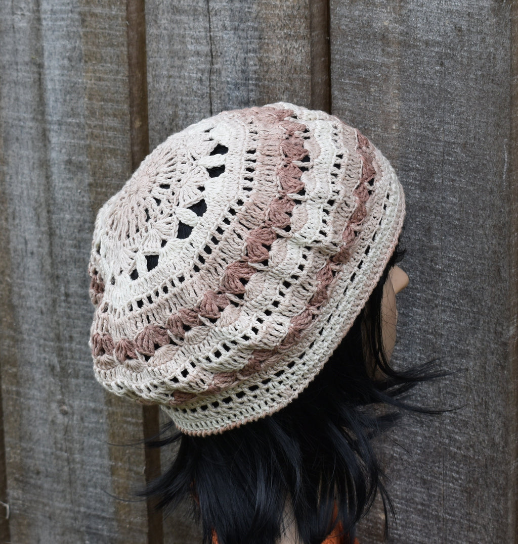 Crocheted beanie with a wavy pattern worn by a person against a wooden background