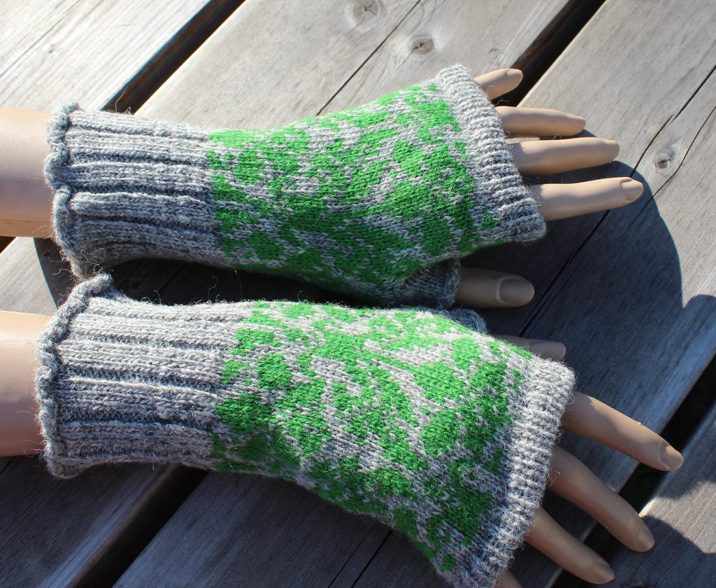 Green and gray fingerless gloves on a wooden surface