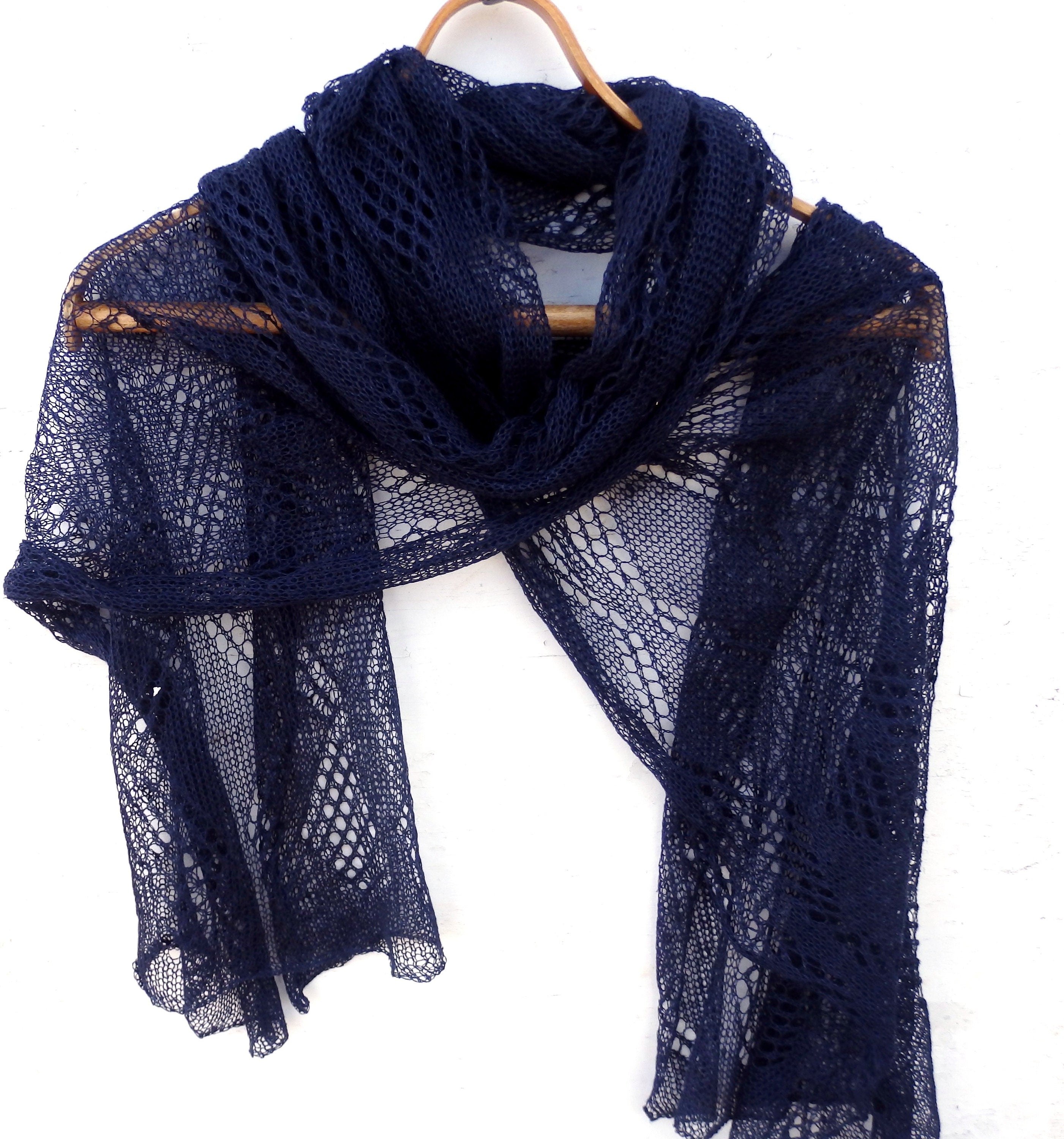 Navy blue lace scarf on a wooden hanger against a white background