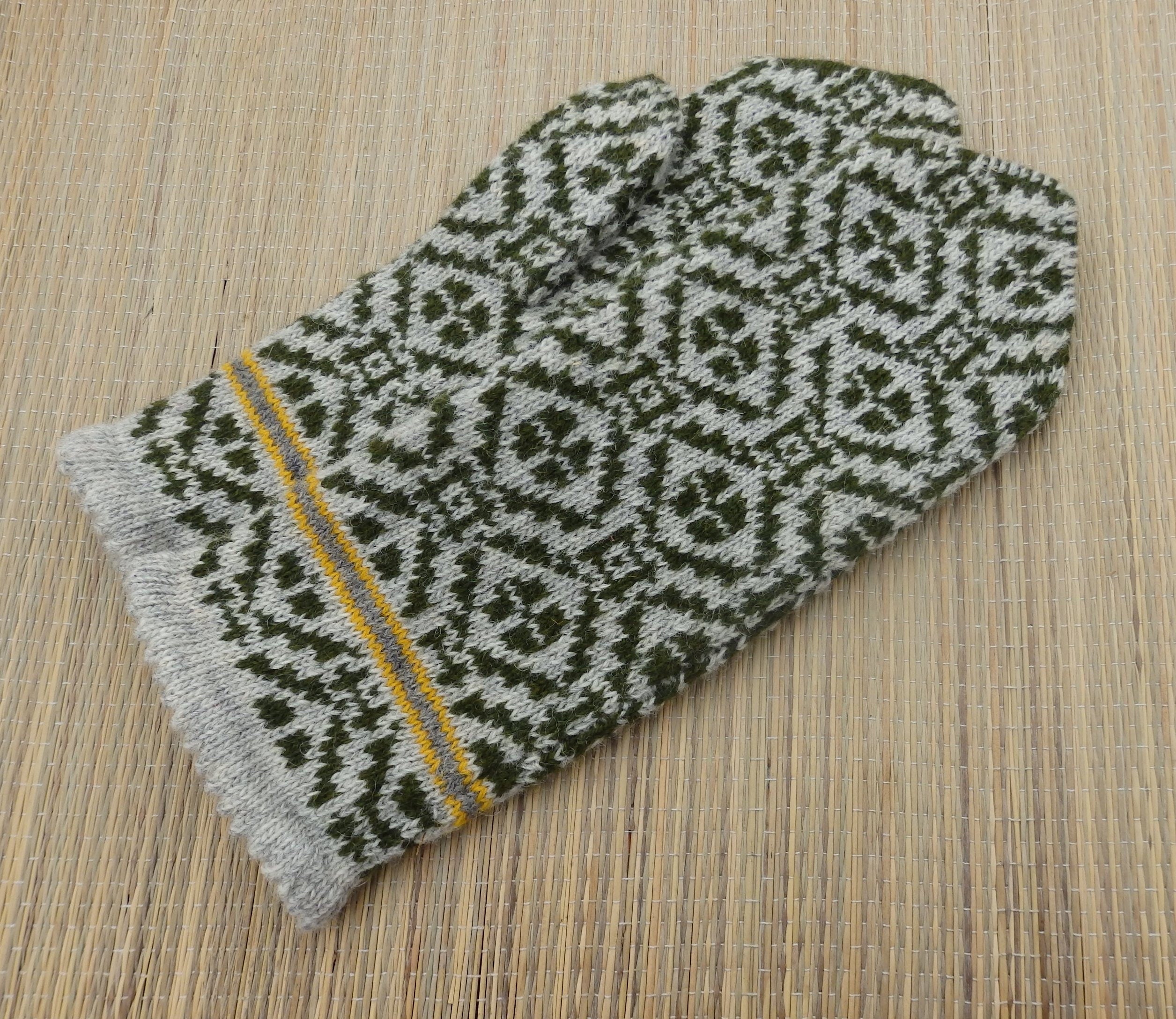 Knitted glove with a geometric pattern on a wooden surface