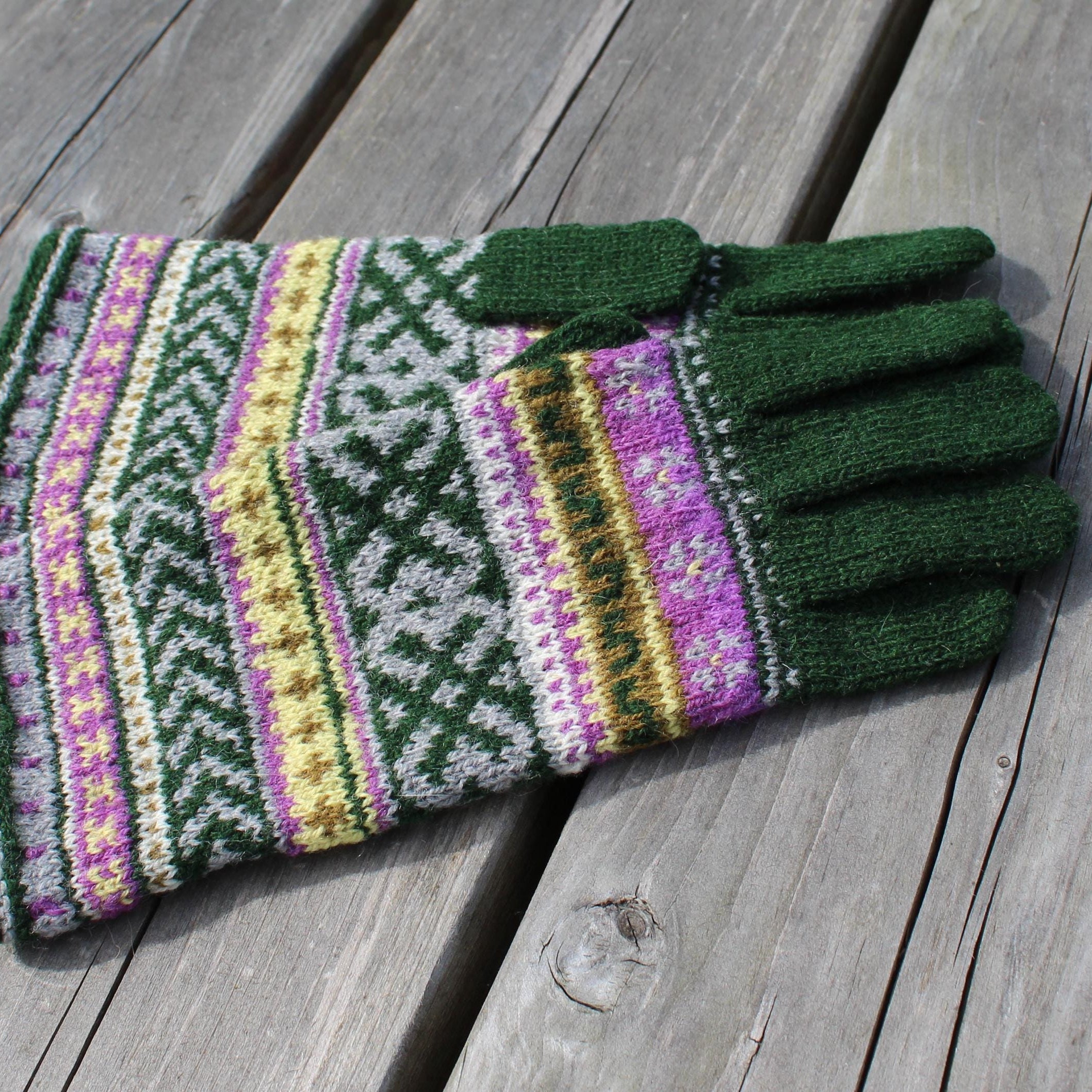 Knitted glove with colorful pattern on a wooden surface