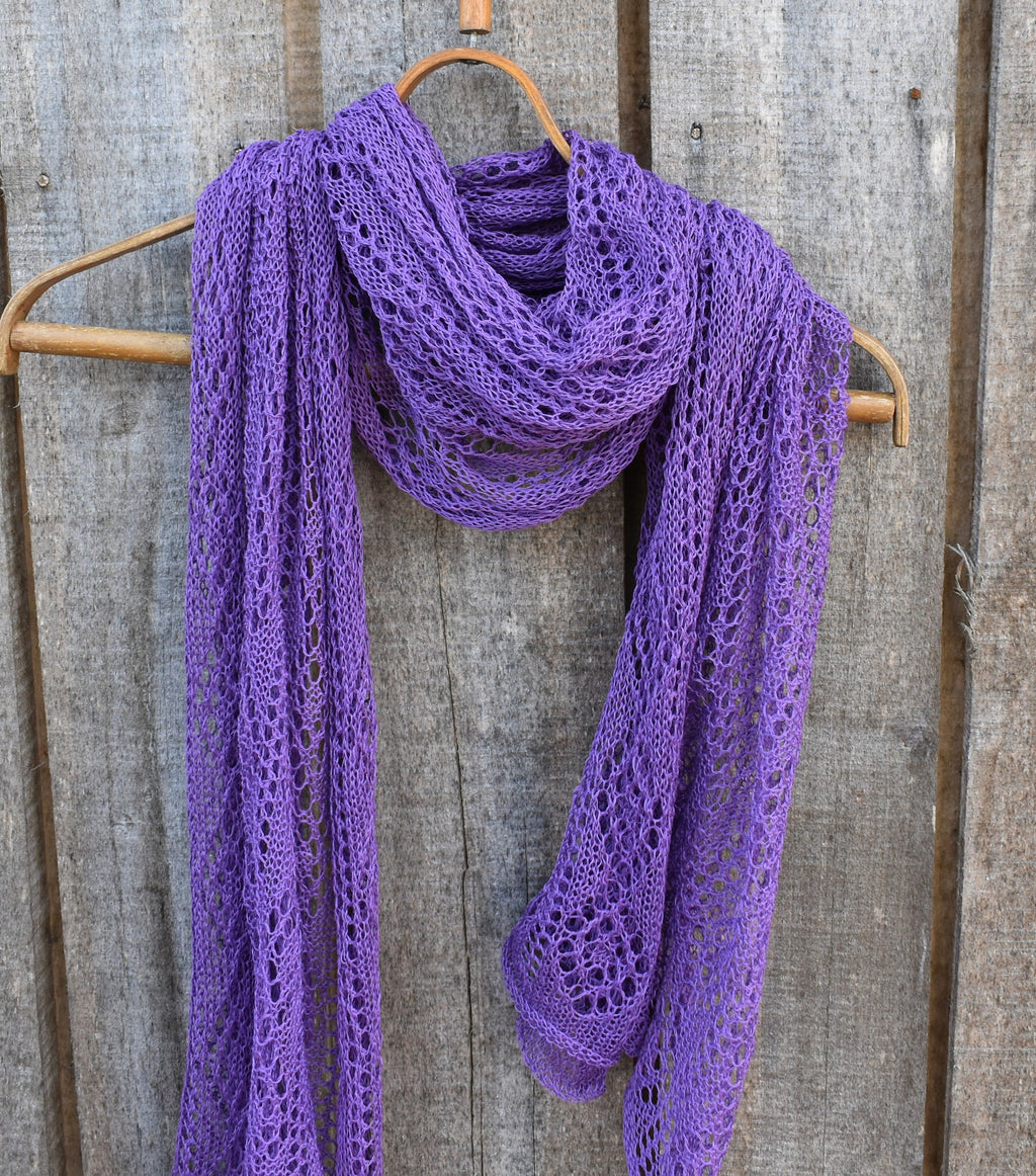 Purple lace scarf on a wooden hanger against a rustic wooden background