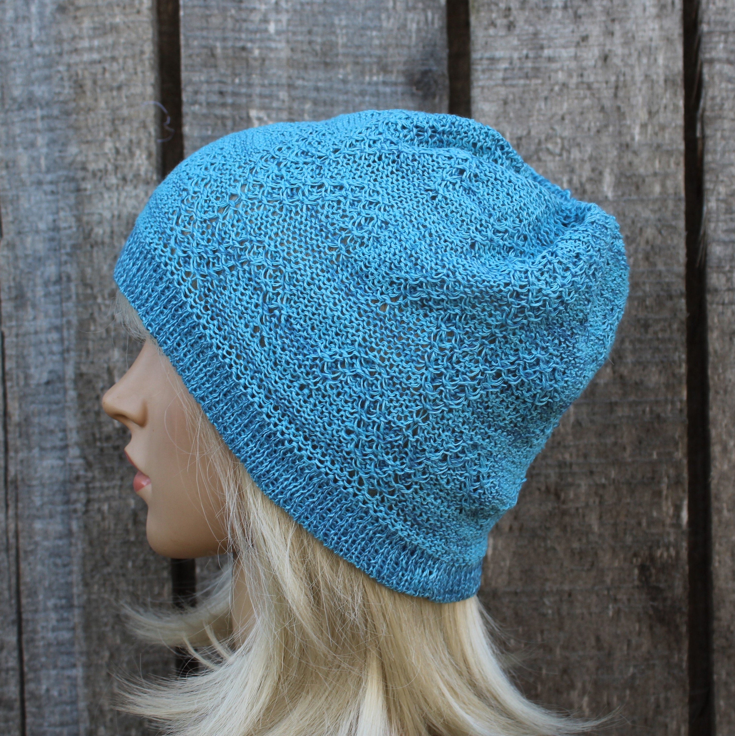 Blue knitted hat on a mannequin head against a wooden background