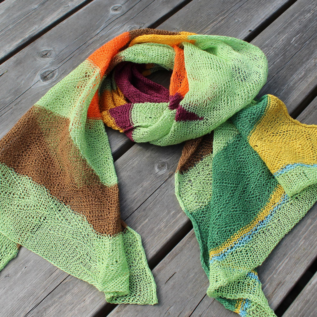Colorful knitted shawl on a wooden surface