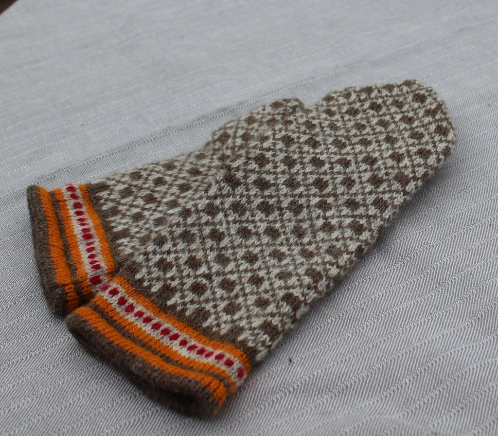 Knitted mitten with a pattern on a gray background