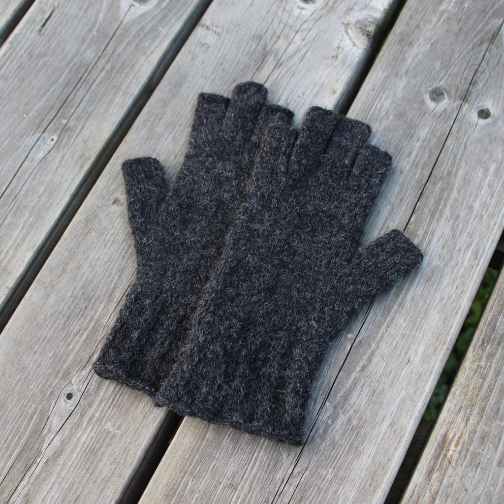 Pair of dark gray gloves on a wooden surface