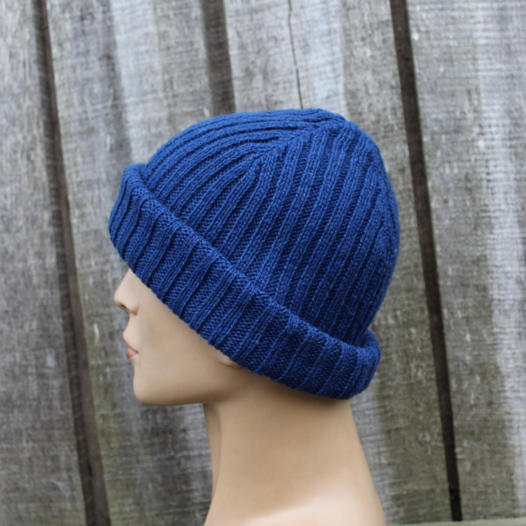 Blue knitted beanie on a mannequin head against a wooden background