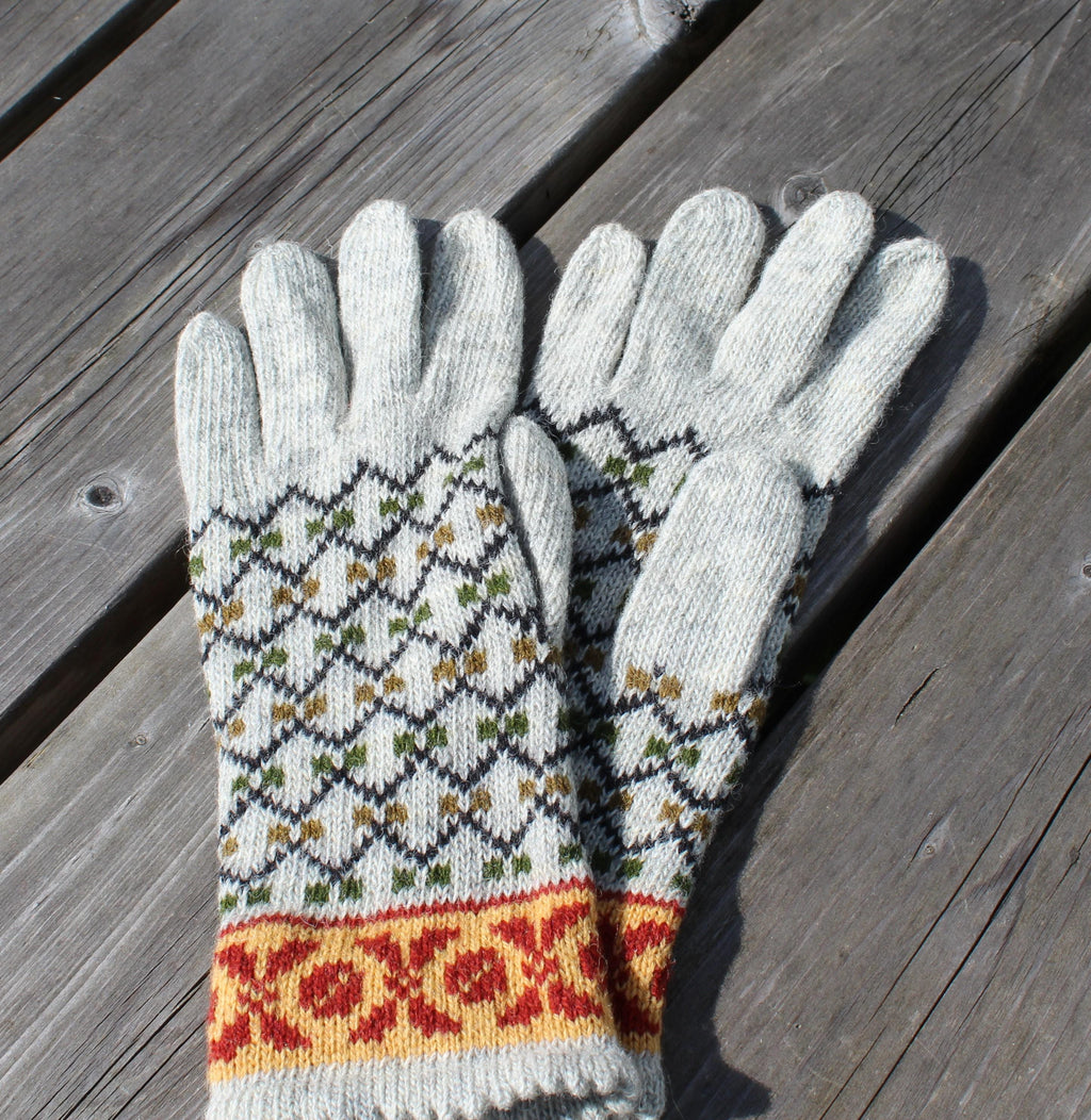 Pair of knitted gloves with a pattern on a wooden surface