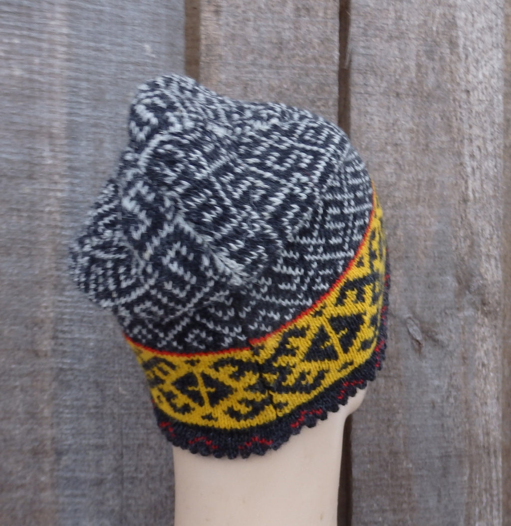 Knitted hat with geometric pattern on a wooden background