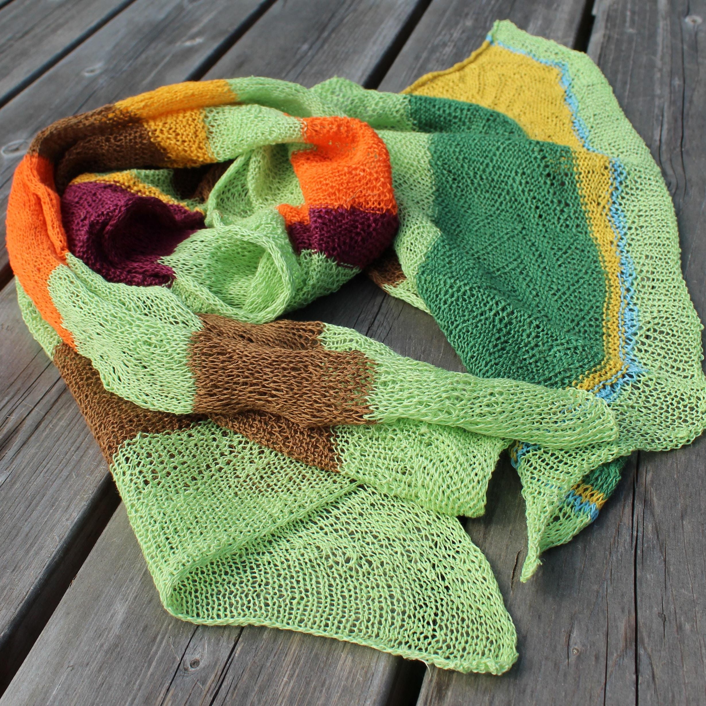 Colorful knitted scarf on a wooden surface