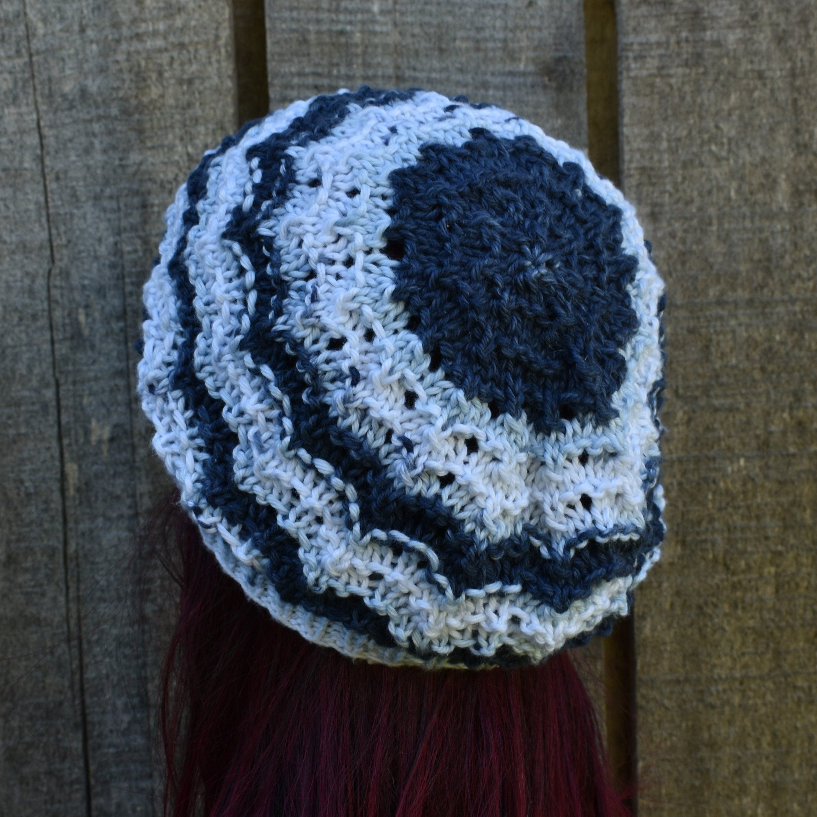 Blue and white patterned knitted hat against a wooden background