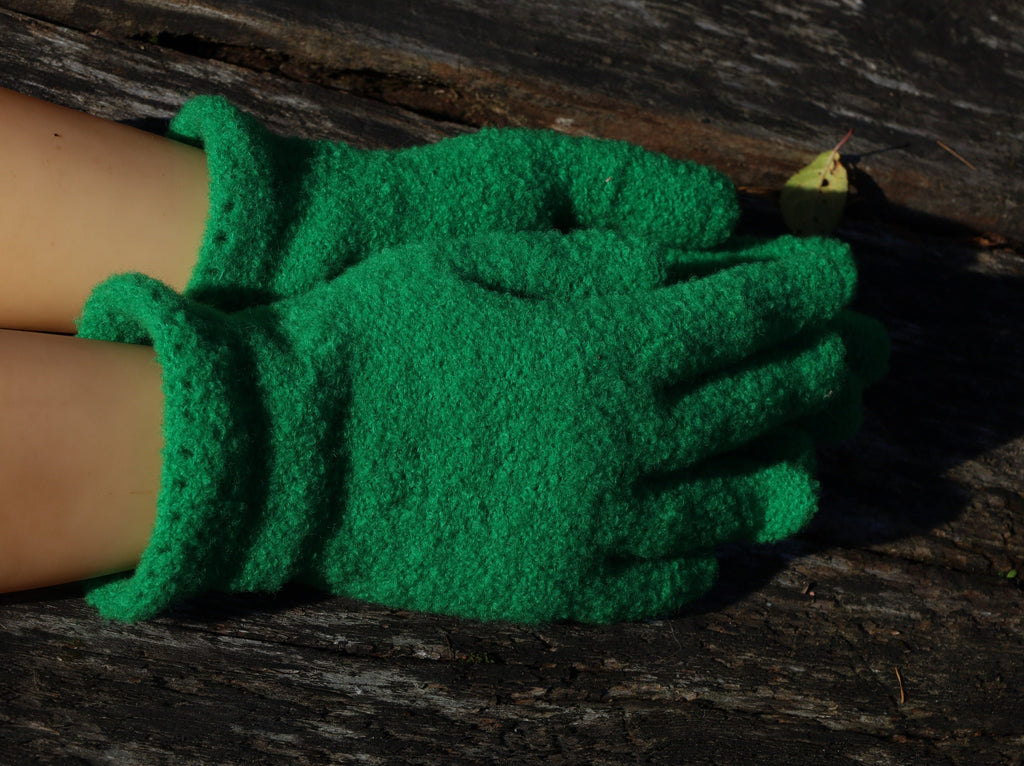 Green gardening gloves on a wooden surface