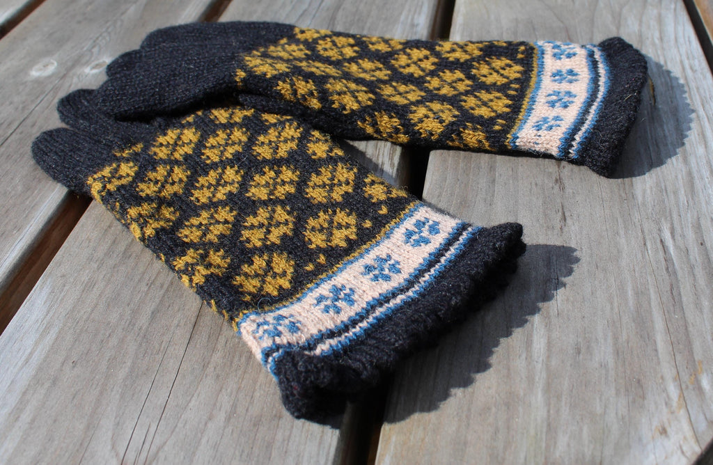 Pair of knitted gloves with a pattern on a wooden surface