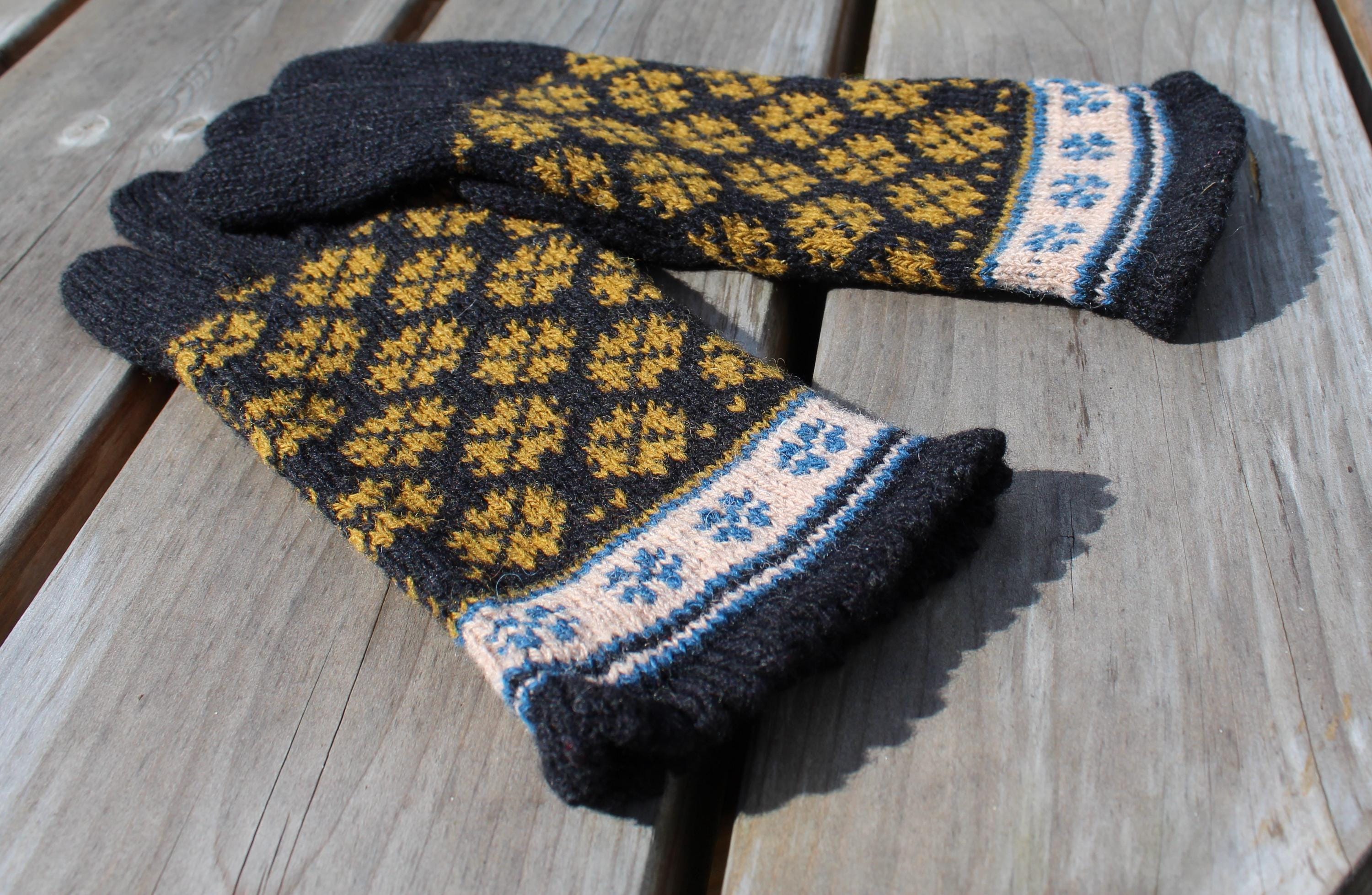 Pair of knitted gloves with a pattern on a wooden surface