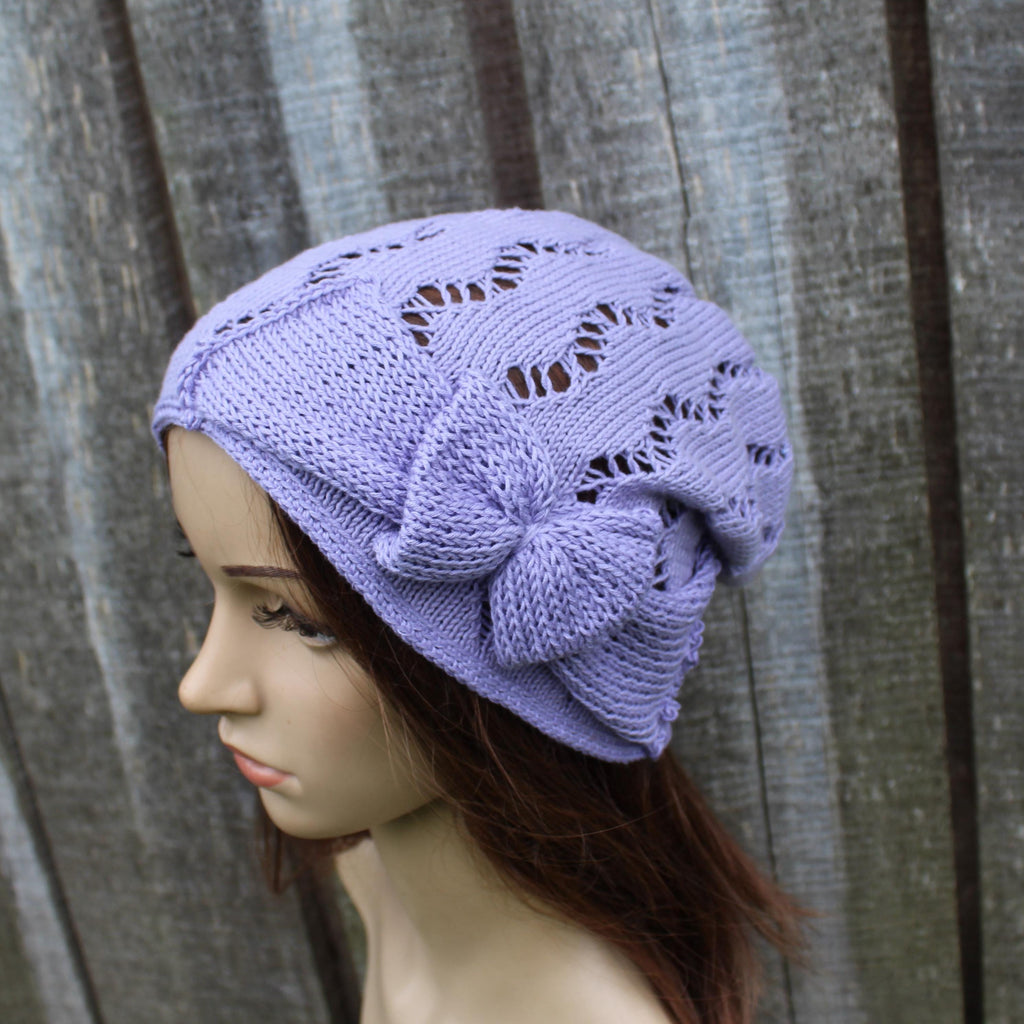 Lavender knitted hat on a mannequin head against a wooden background