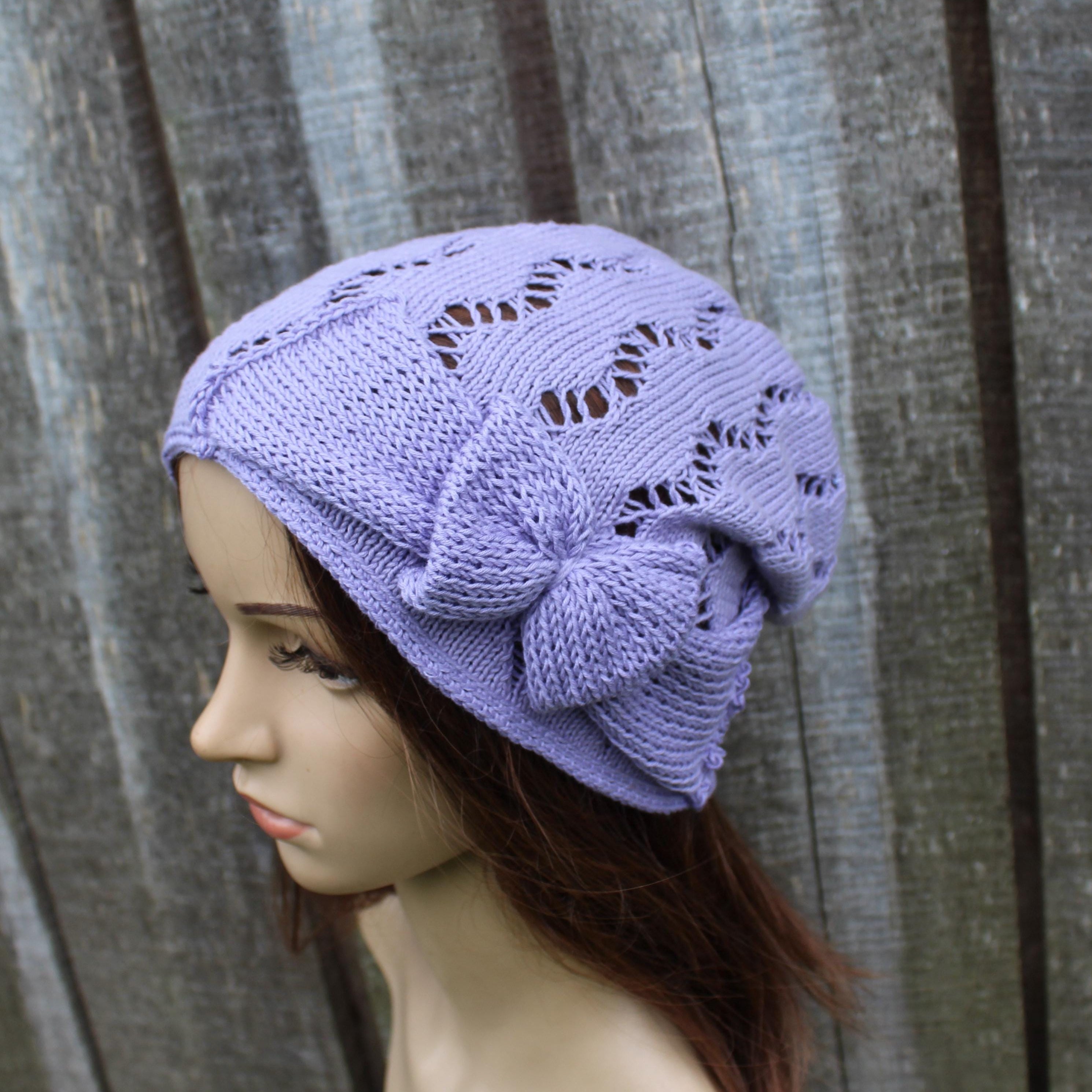 Lavender knitted hat on a mannequin head against a wooden background