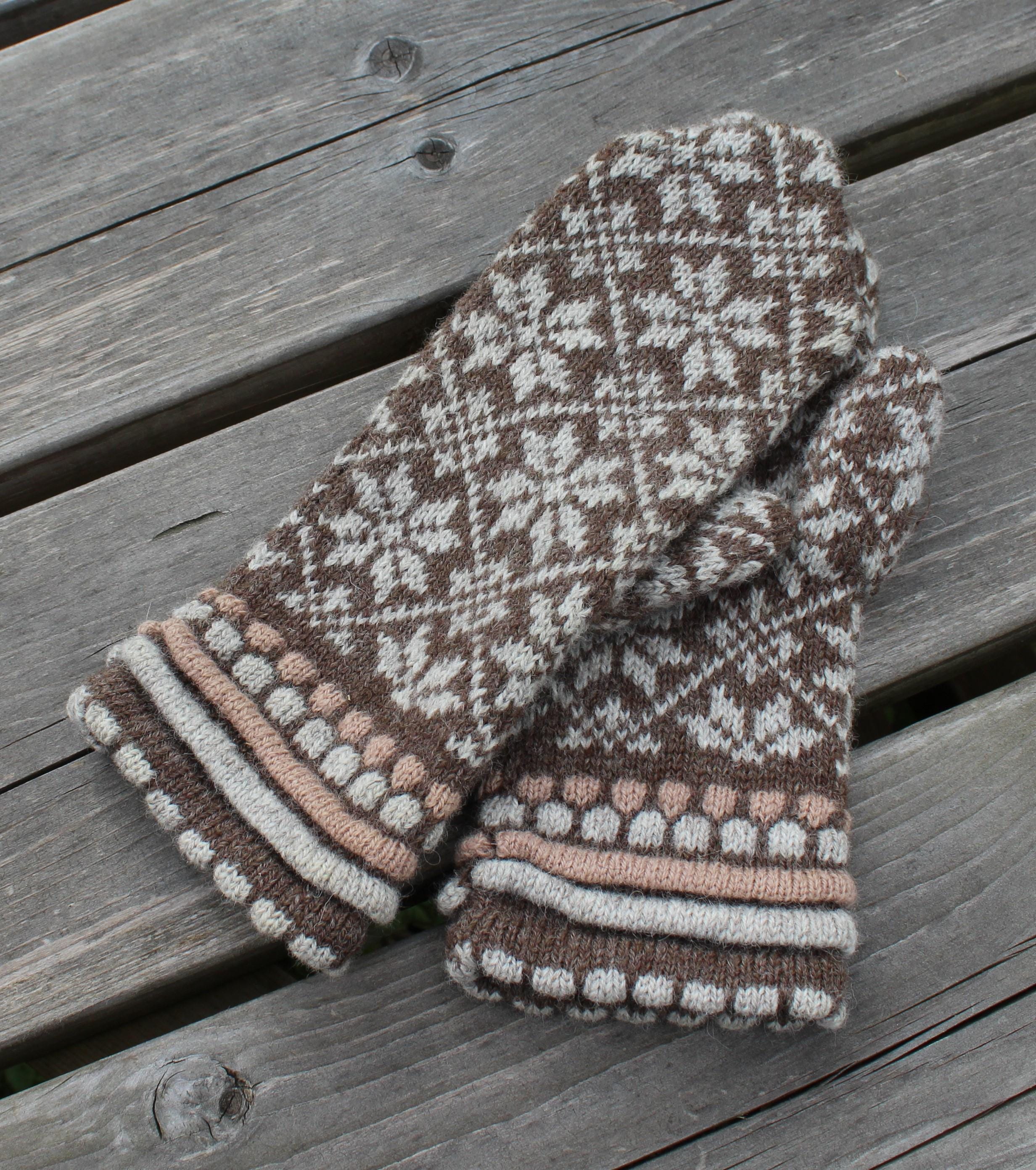 Pair of patterned mittens on a wooden surface