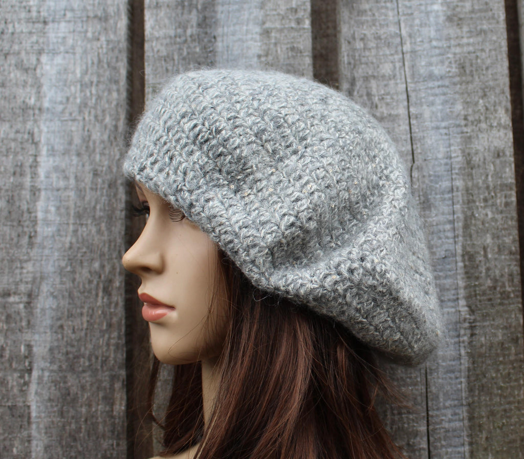 Mannequin head wearing a gray knitted hat against a wooden panel background