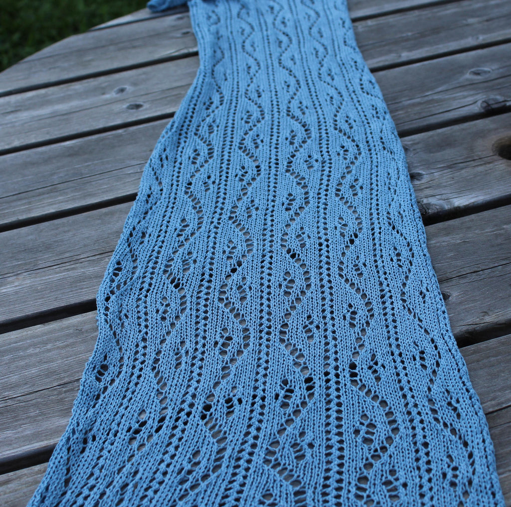 Blue knitted scarf on a wooden surface