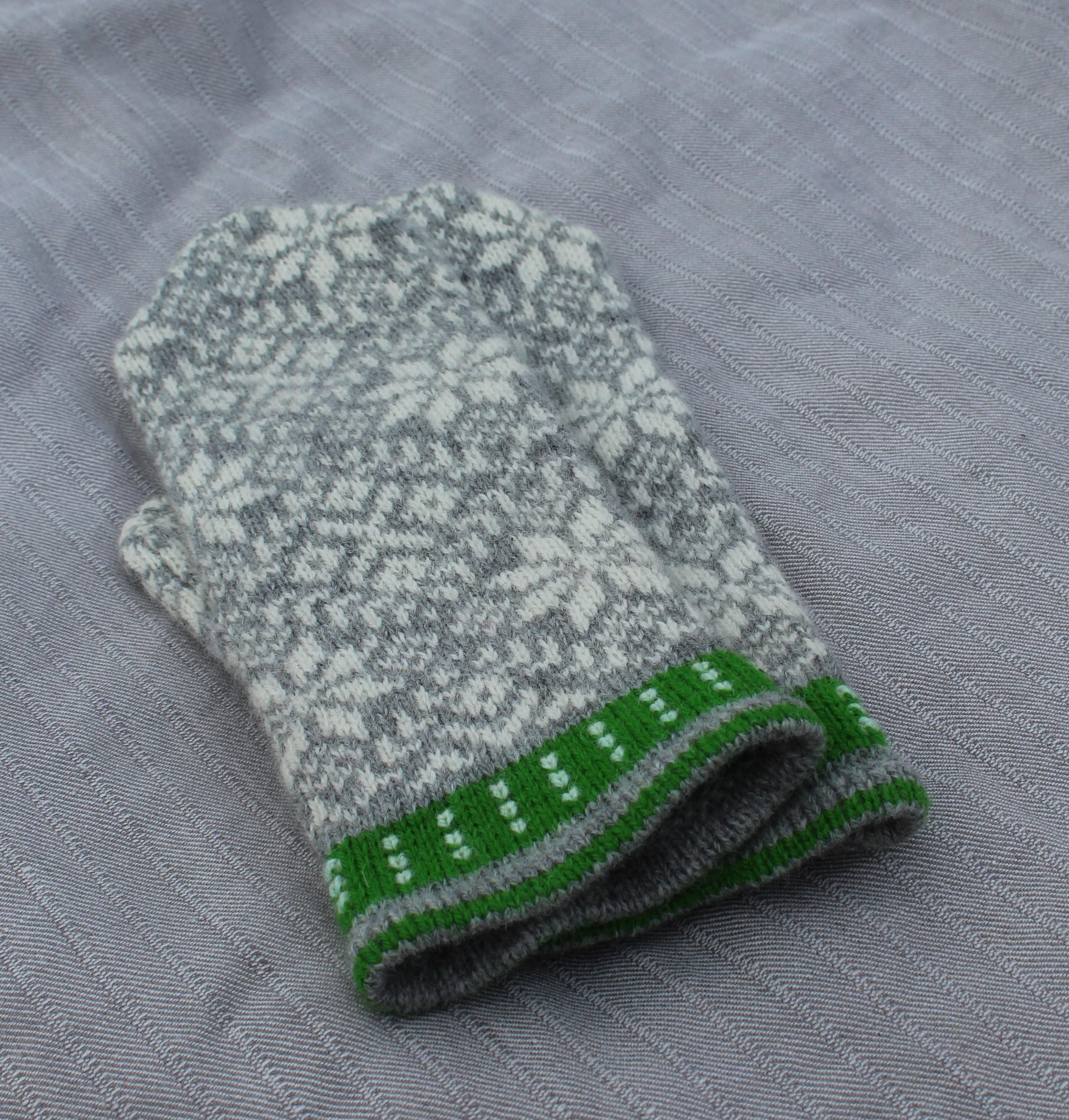 Knitted glove with a pattern on a gray fabric background