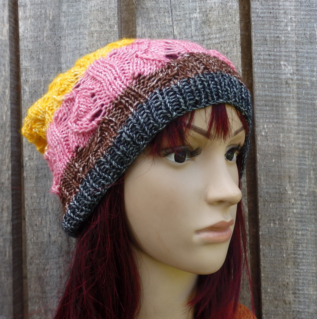 Colorful knitted beanie on a mannequin head against a wooden background