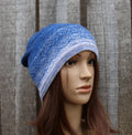 Blue knitted beanie on a mannequin head against a wooden background