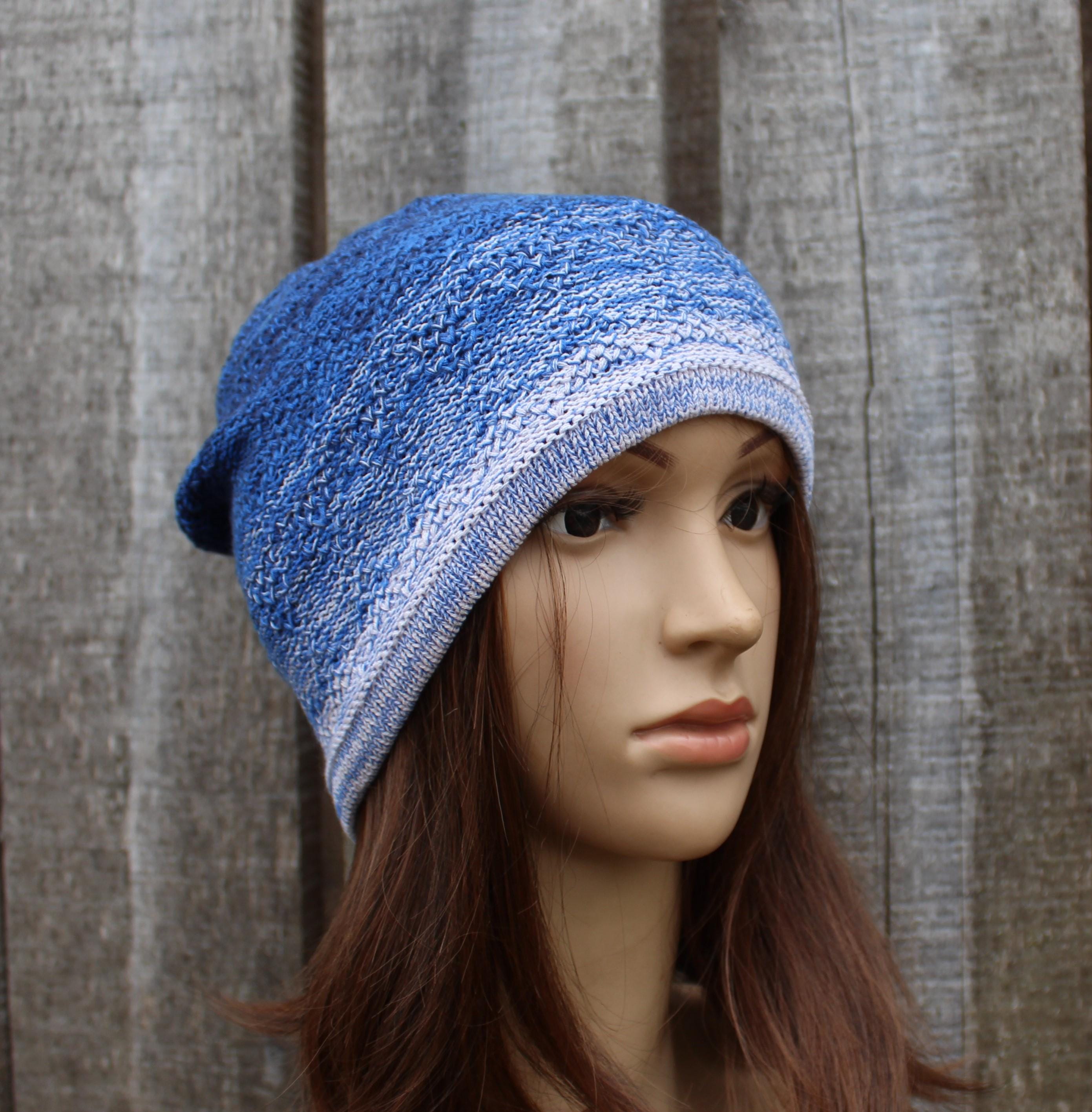 Blue knitted beanie on a mannequin head against a wooden background