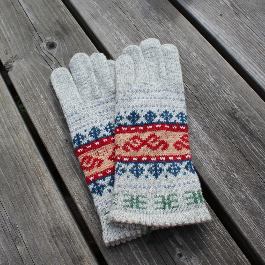 Pair of gray gloves with colorful fair Isle patterns on a wooden surface