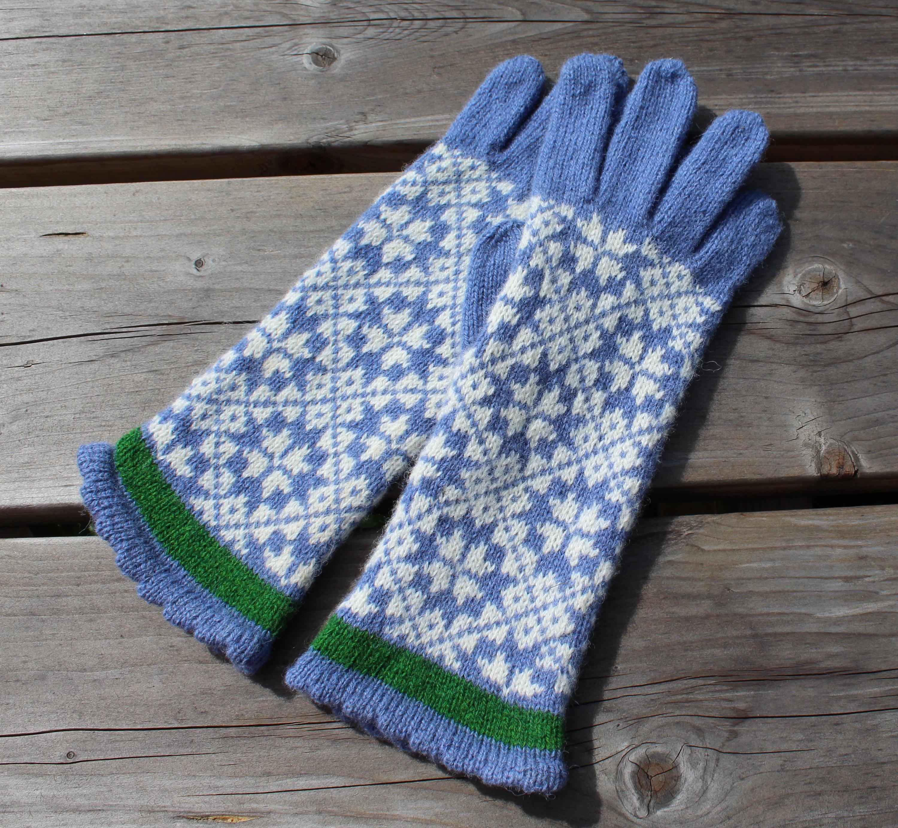 Pair of blue and white patterned gloves on a wooden surface