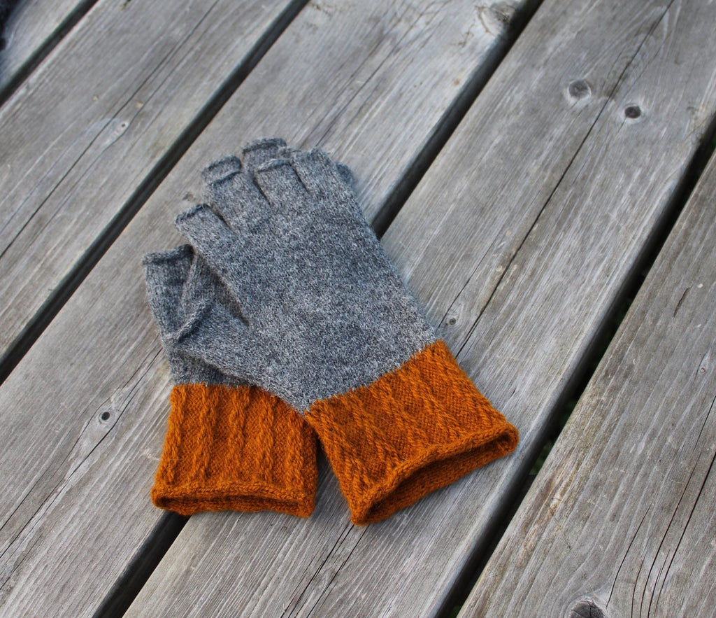 Gray and orange gloves on a wooden surface