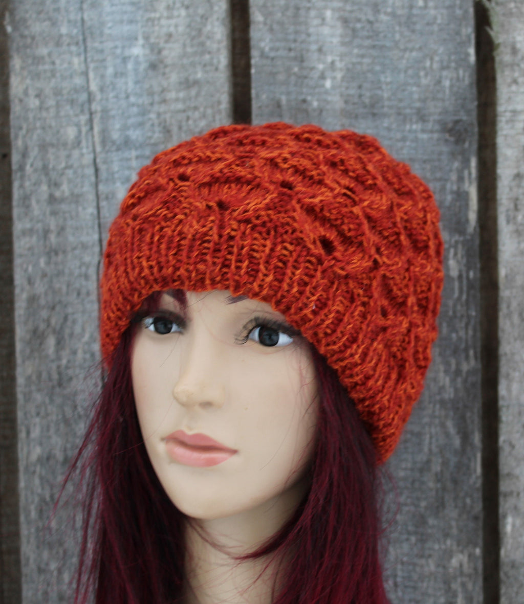 Red knitted hat on a mannequin head against a wooden background