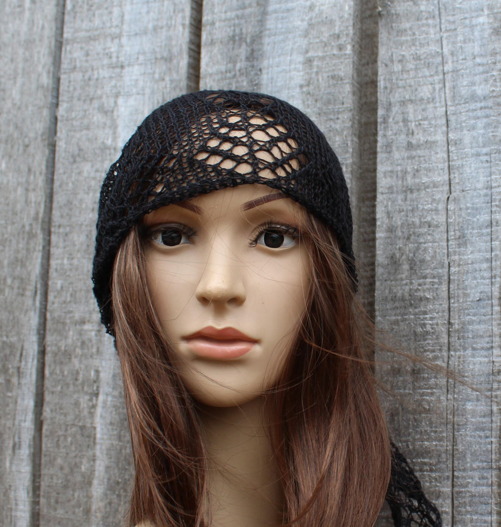 Mannequin head wearing a black lace headband against a wooden background
