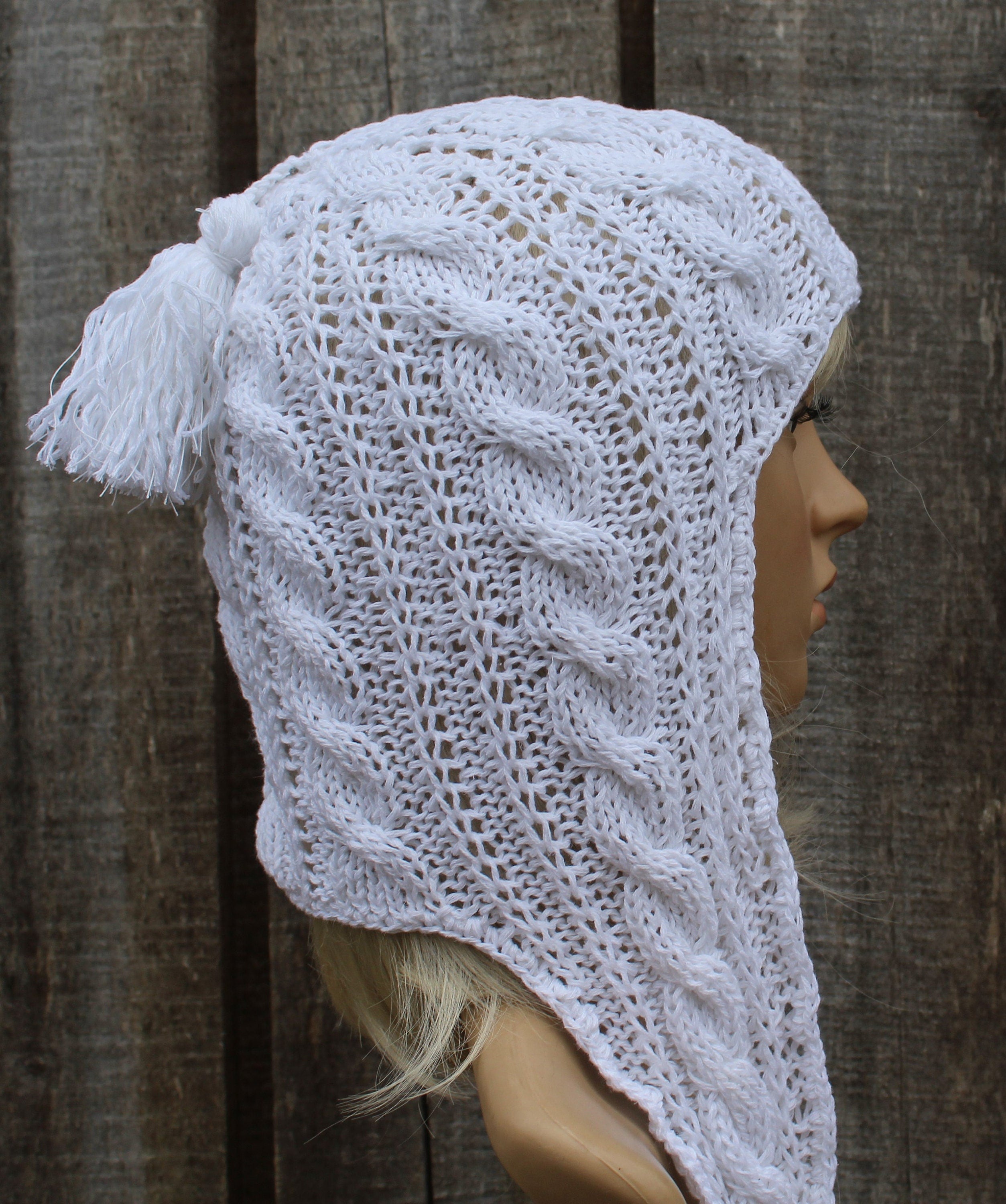White knitted hood on a mannequin against a wooden background