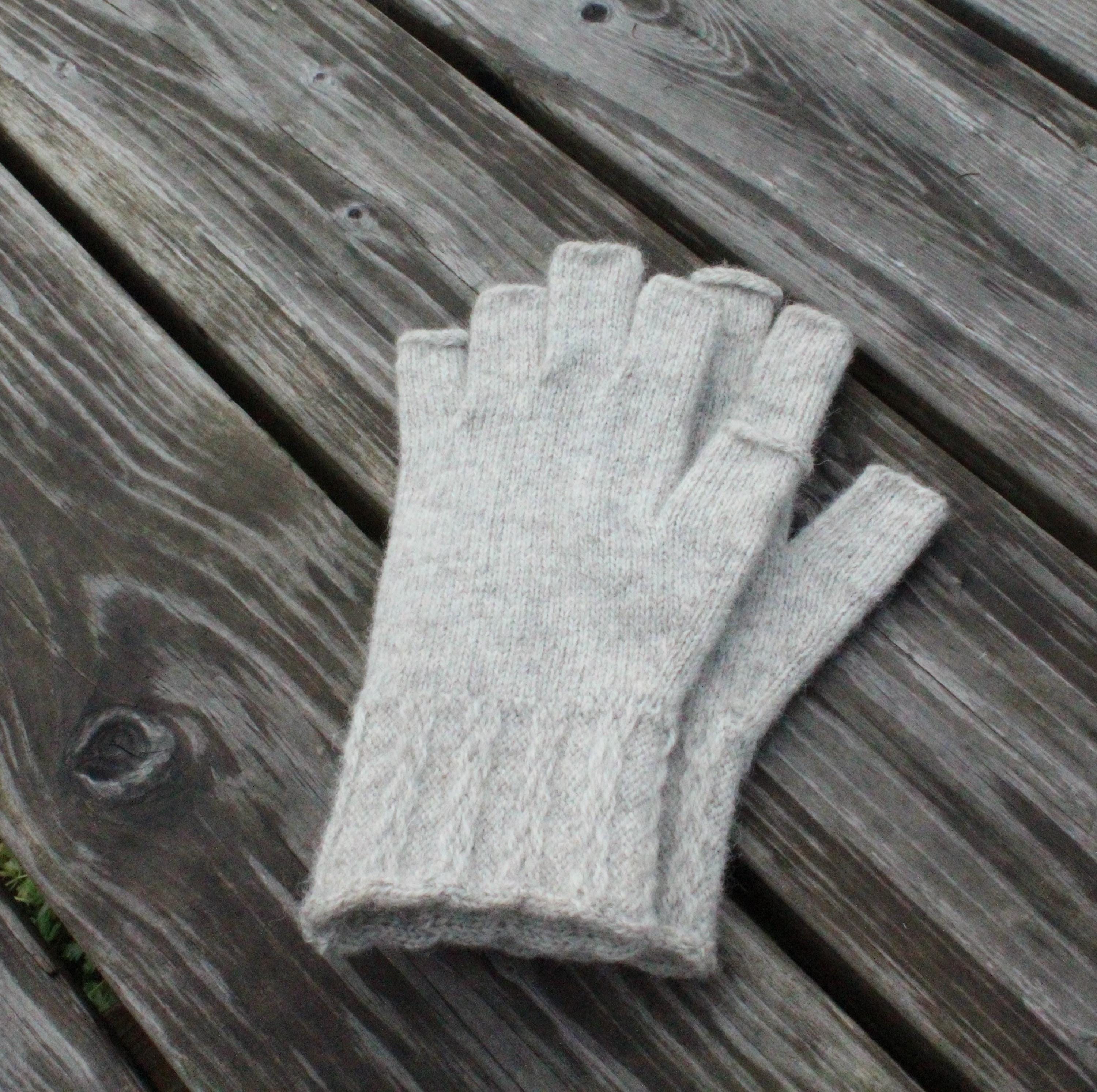 Gray fingerless gloves on a wooden surface