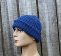 Blue knit beanie on a mannequin head against a wooden background