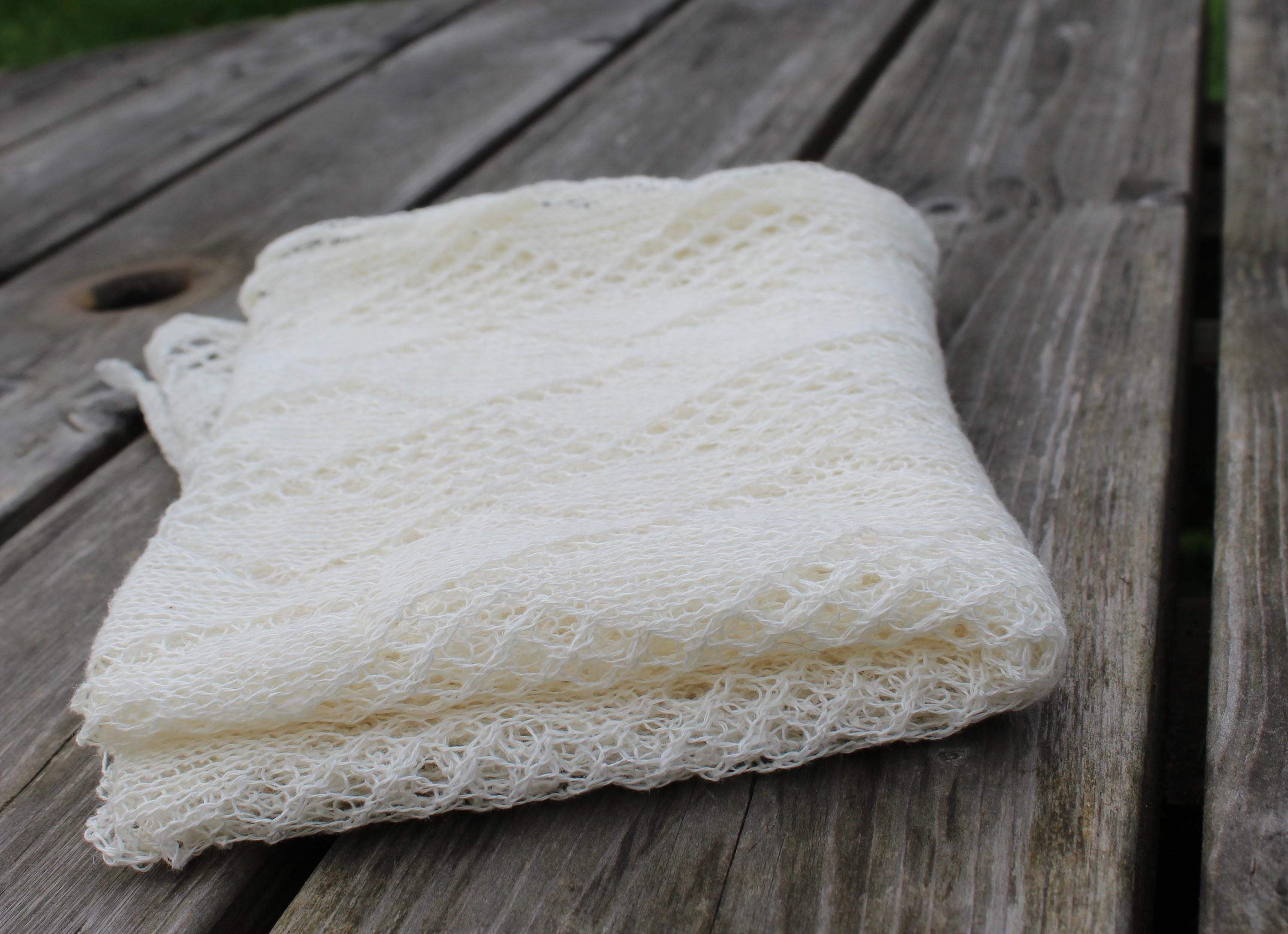 Folded white loofah on a wooden surface