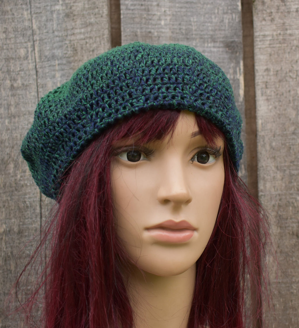 Green crocheted beanie on a mannequin head against a wooden background