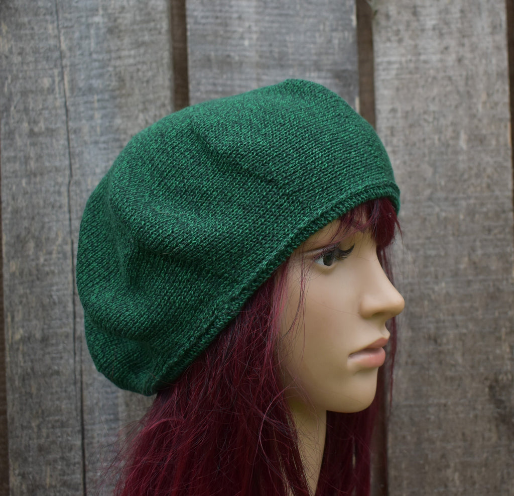 Green knitted hat on a mannequin head against a wooden background