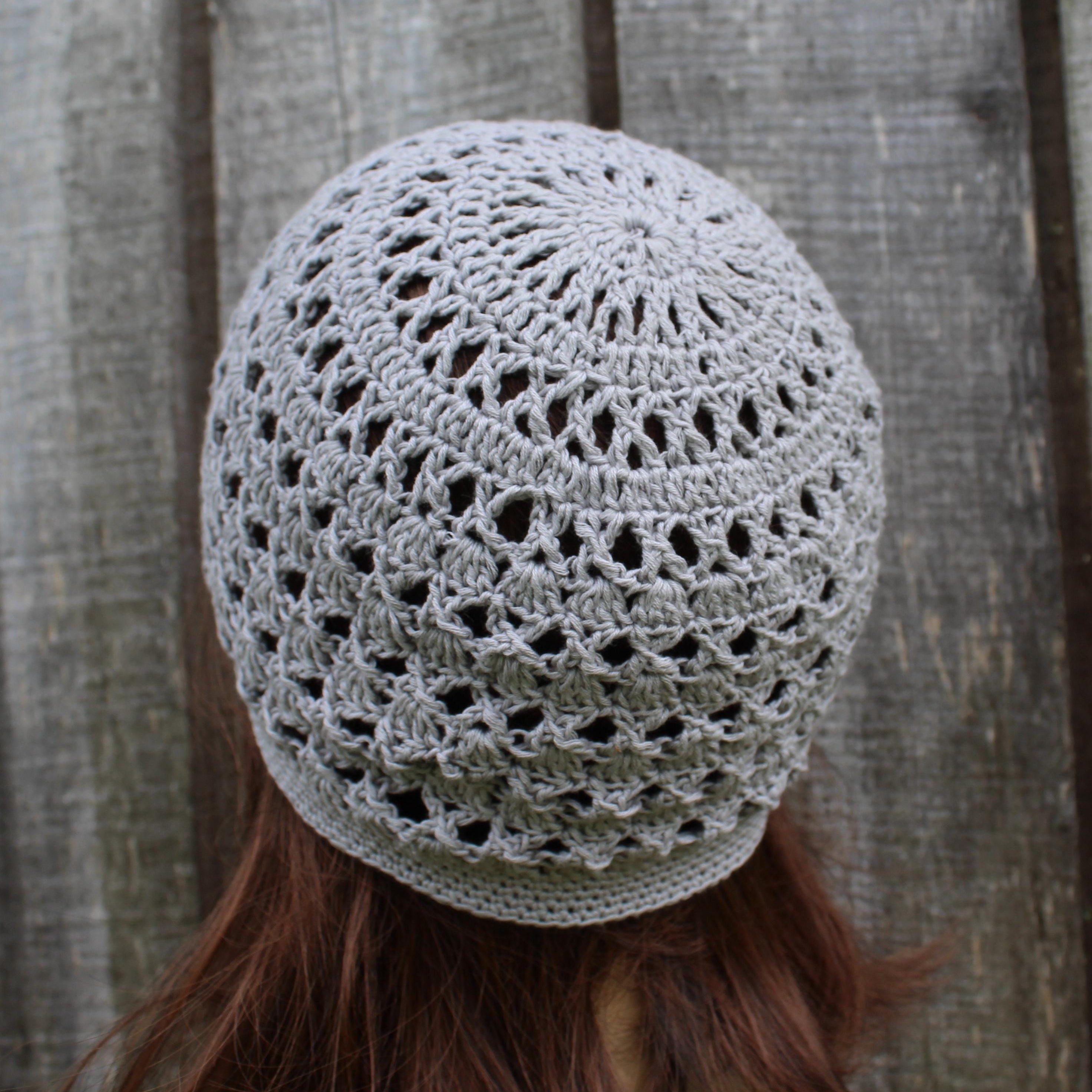Crocheted gray beanie worn by a person with a wooden background