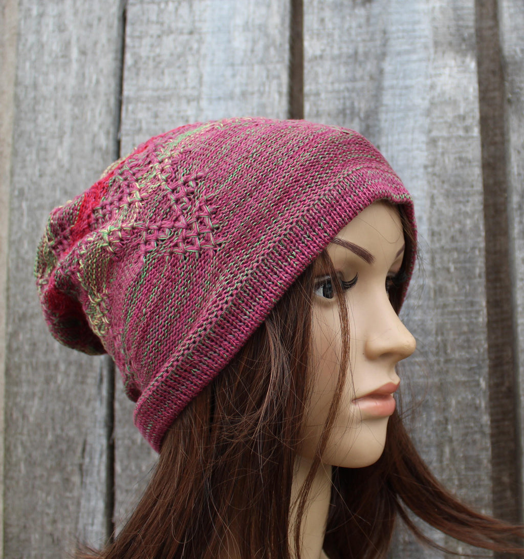 Knitted pink hat on a mannequin head against a wooden background