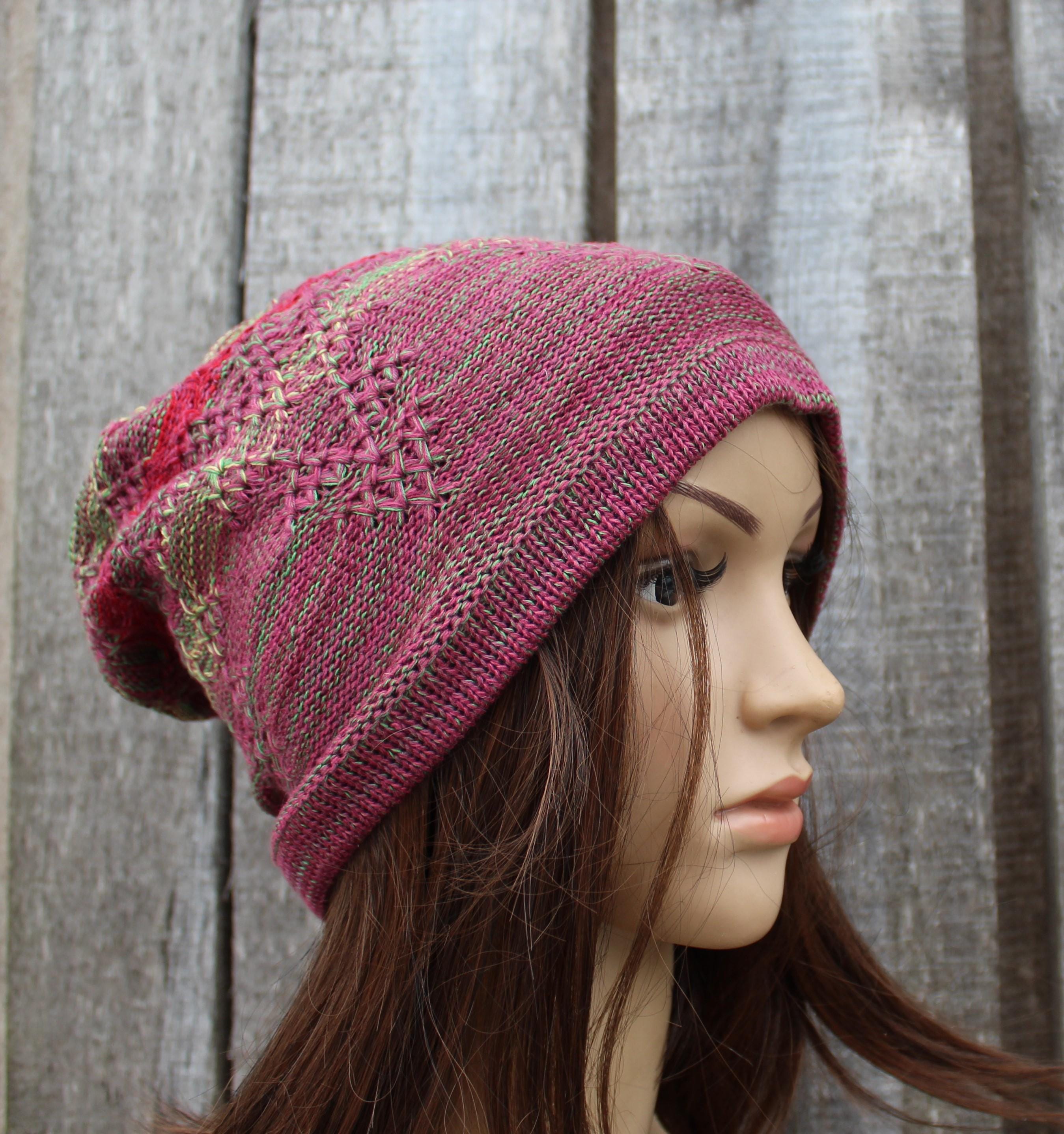 Knitted pink hat on a mannequin head against a wooden background