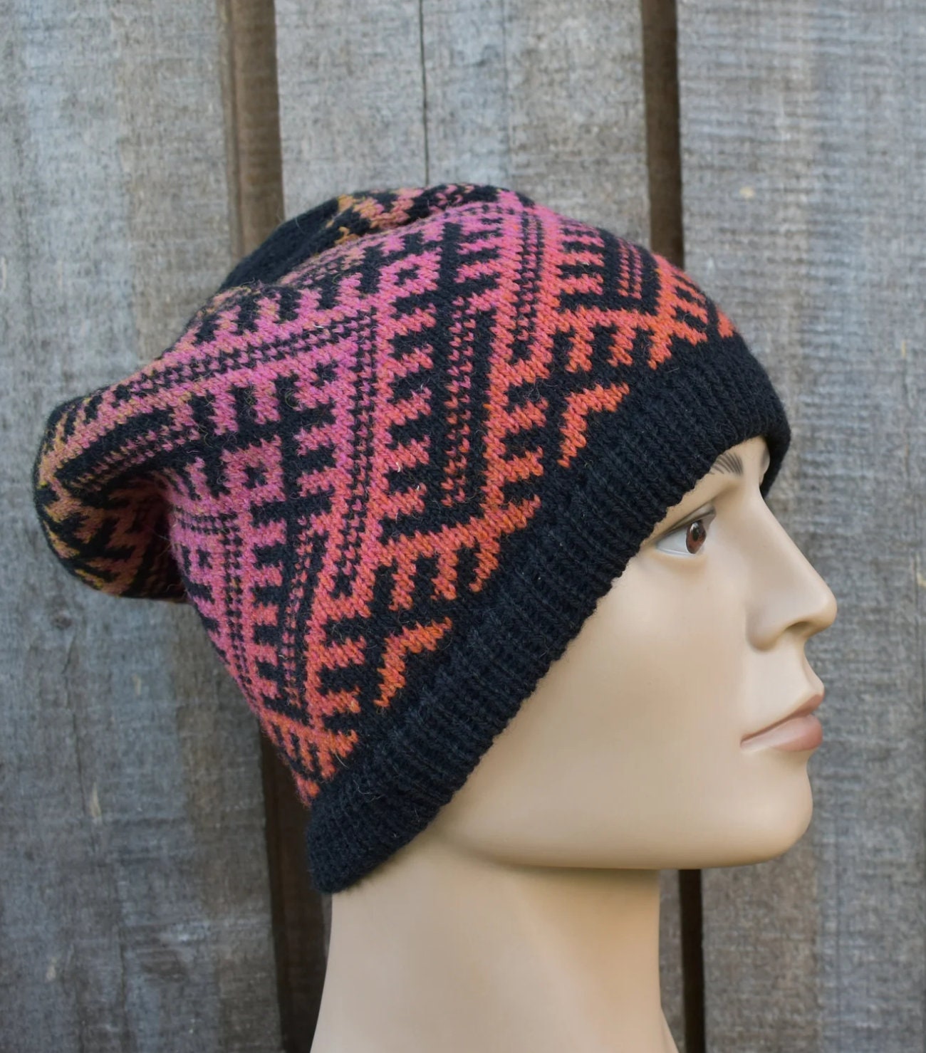 Knitted hat with a geometric pattern on a mannequin head against a wooden background