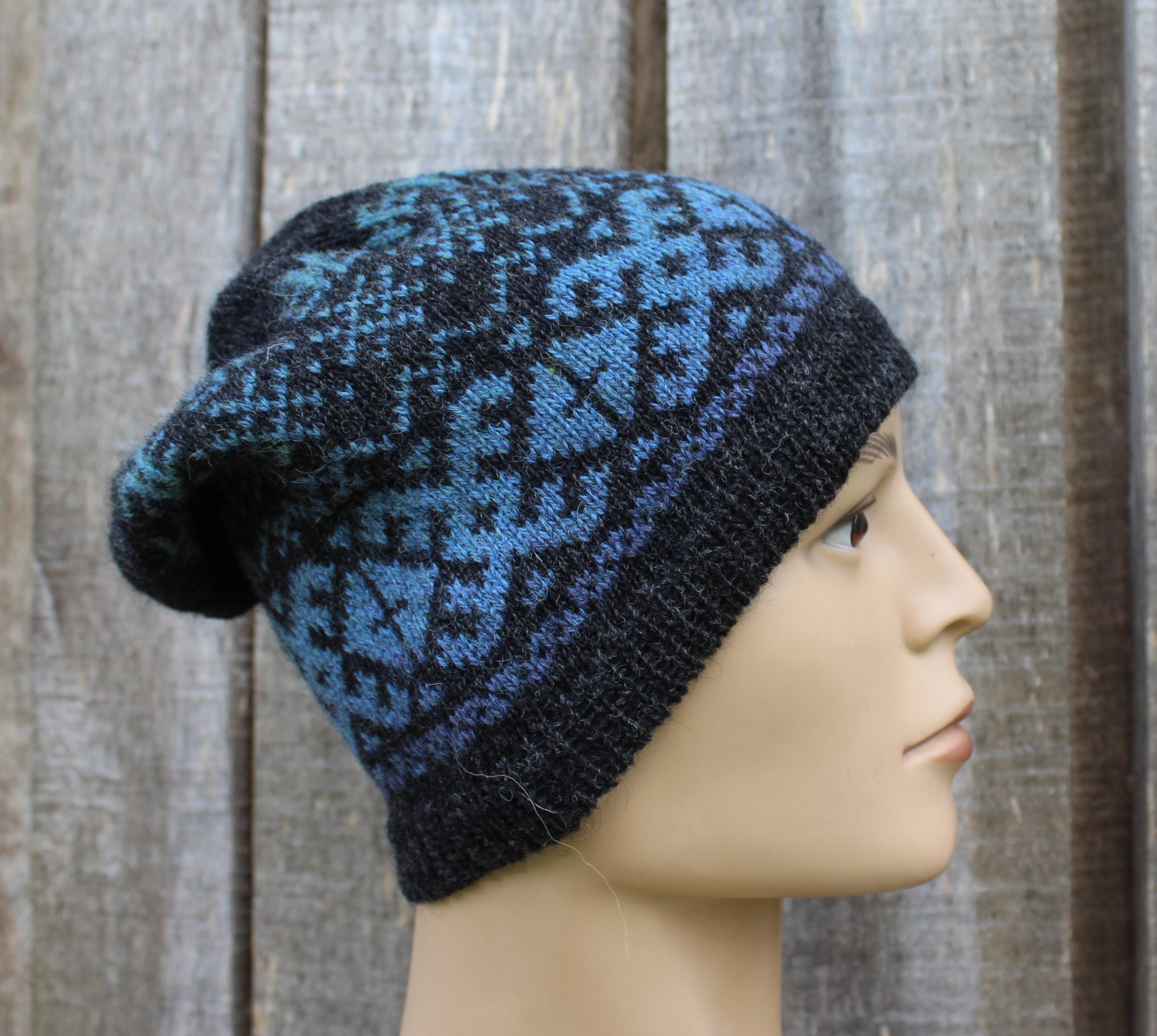Blue and black patterned knit beanie on a mannequin head against a wooden background