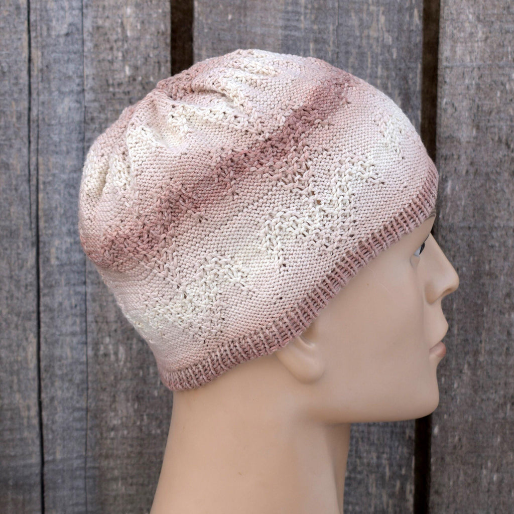 Knitted beige beanie on a mannequin head against a wooden background