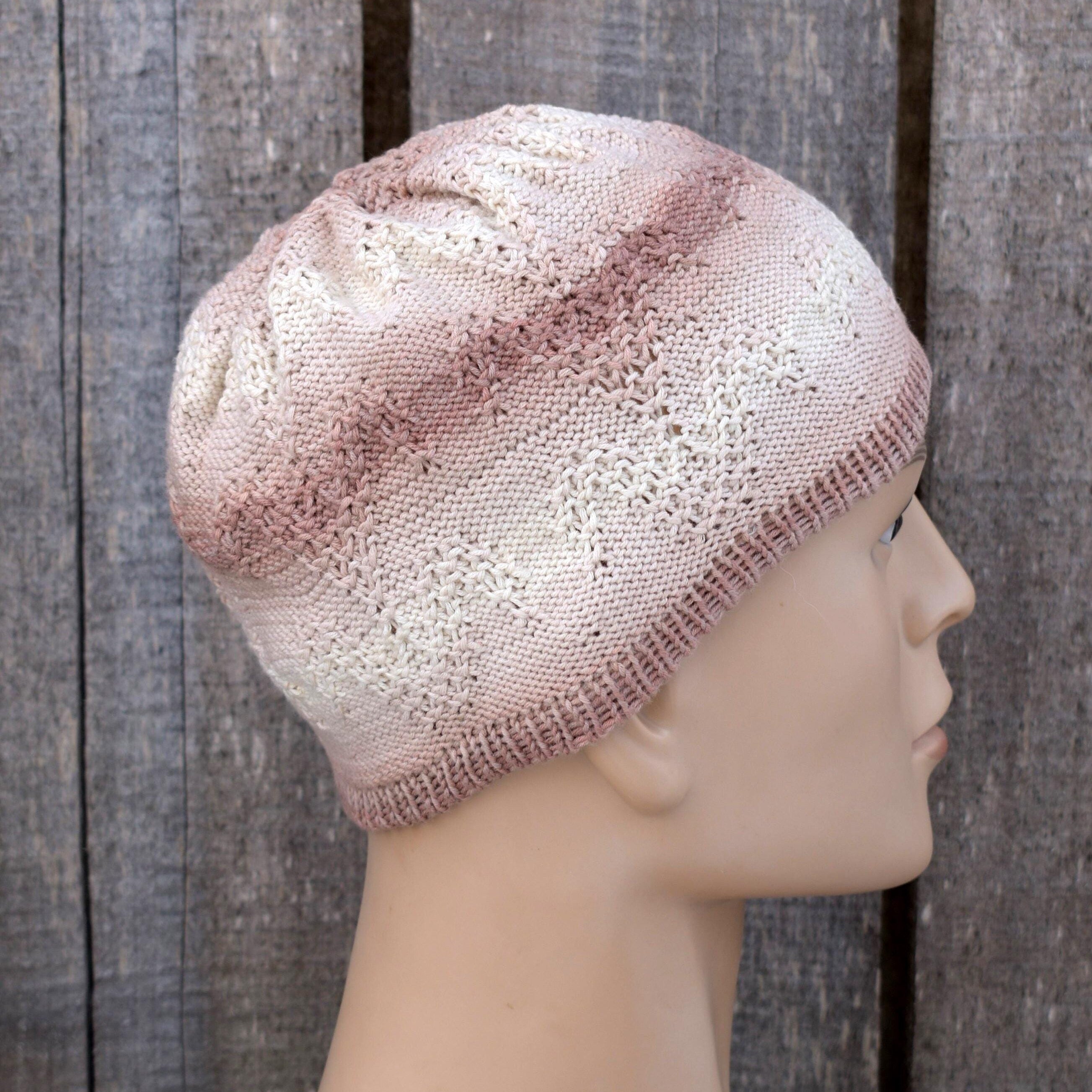 Knitted beige beanie on a mannequin head against a wooden background